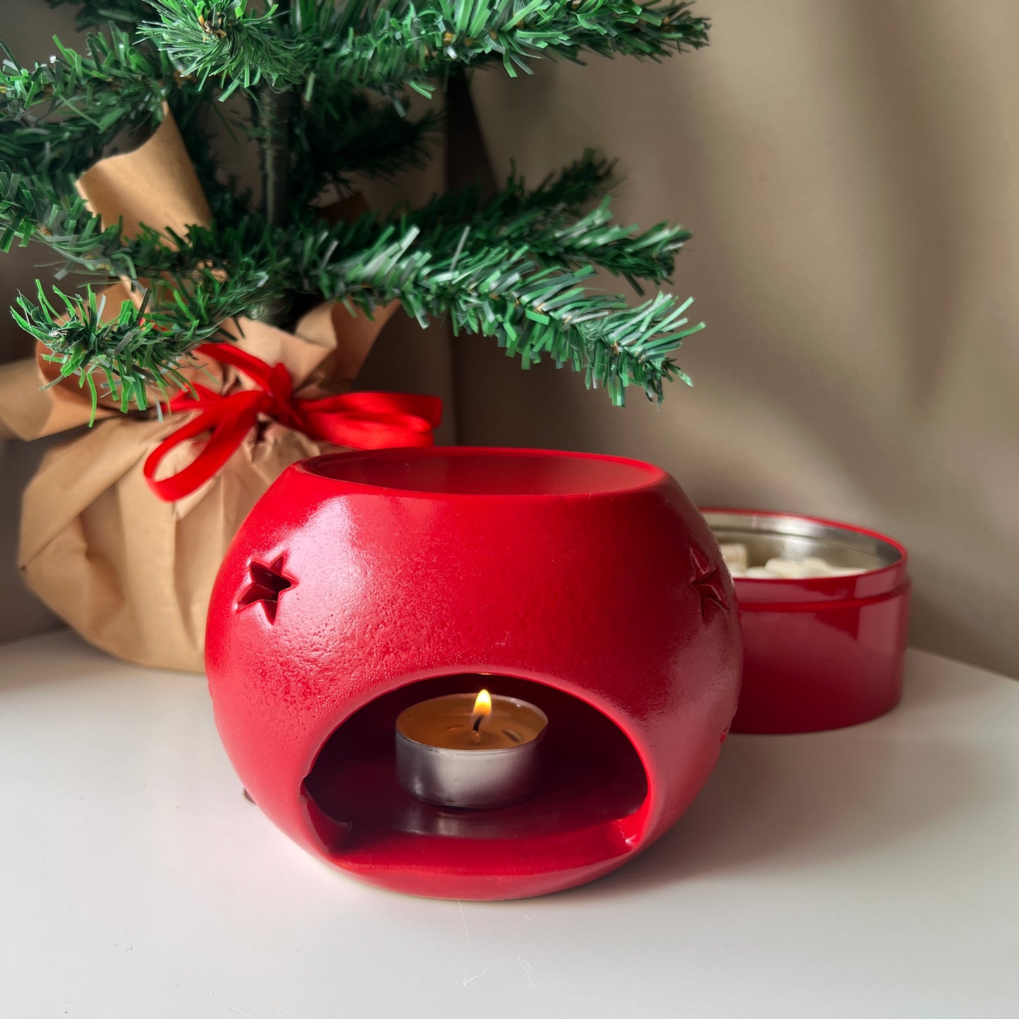 Handcrafted Christmas ornament-shaped wax melter with a festive red and white design, featuring a tealight holder and a wax melt tray, perfect for creating a cozy holiday ambiance.