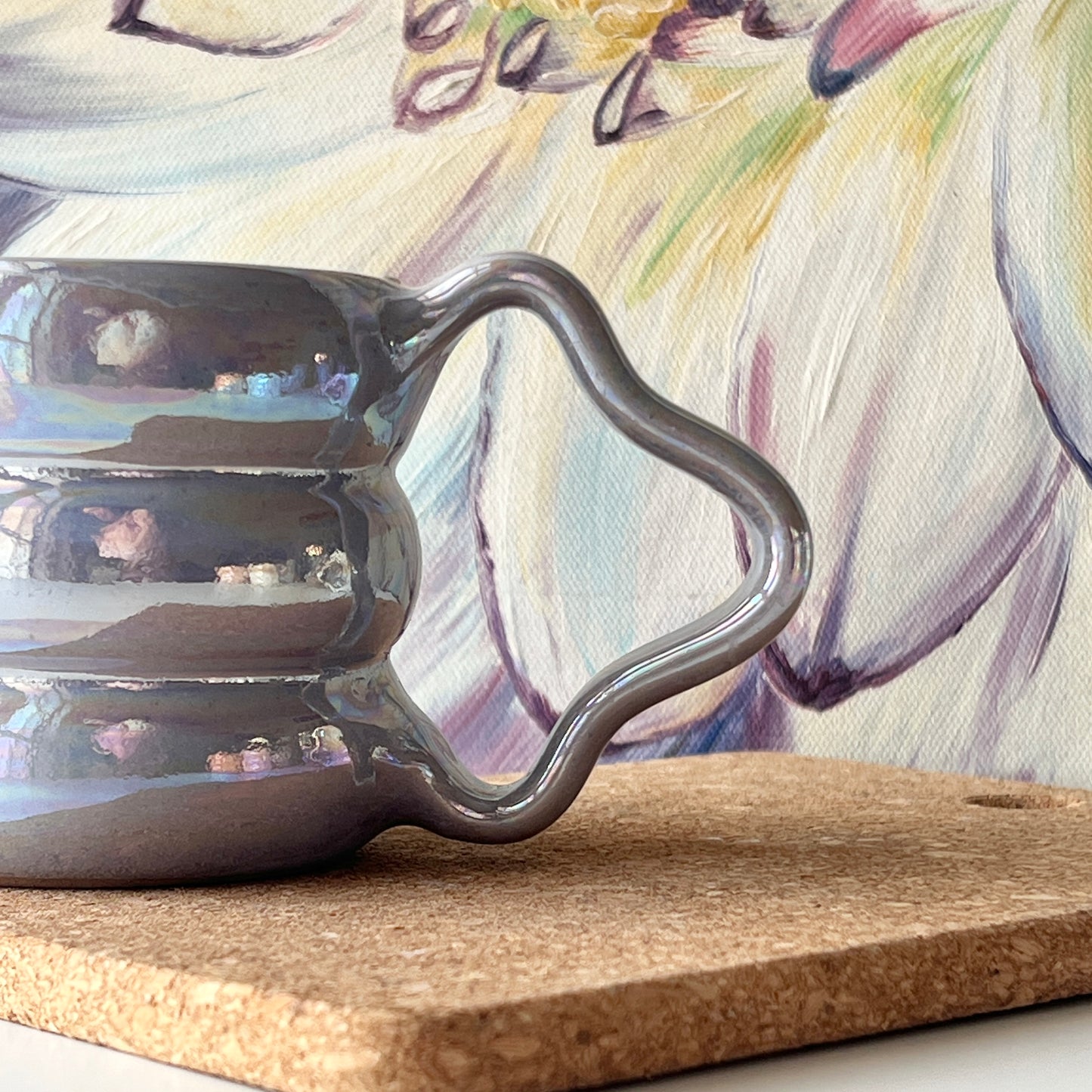 The handcrafted mug showcasing its shimmering luster and sculpted handle up close.