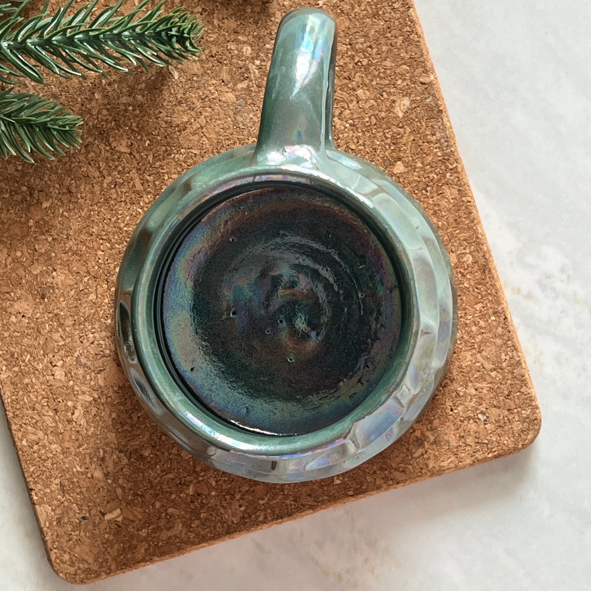 Top view of handmade ceramic Christmas mug with tree design.