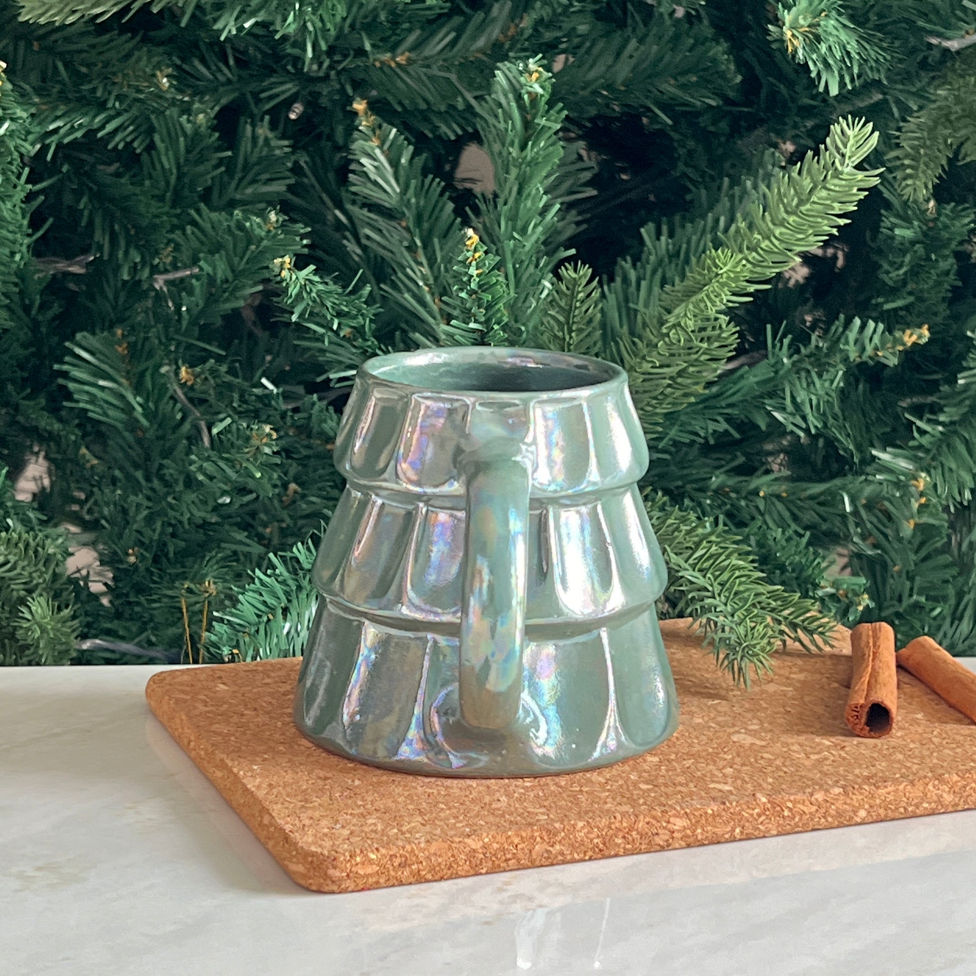 Side profile of festive green ceramic tree mug for holidays.