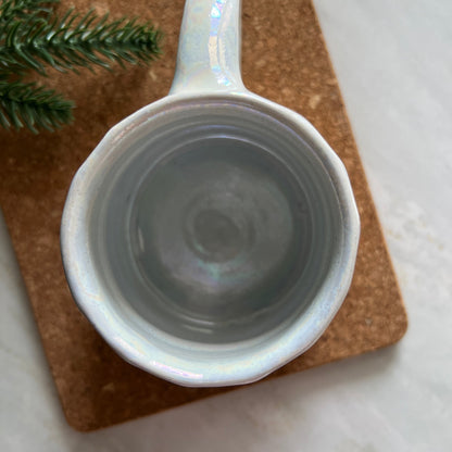 Top view of handmade ceramic Christmas mug in white with tree design.